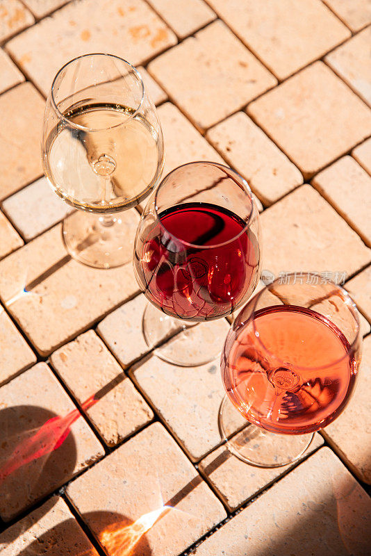 Wine glass variety with red, white and rosé wine at vineyard wine tasting in sunlight